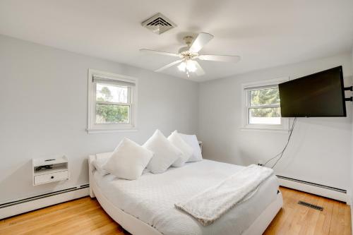 a white bedroom with a bed and a flat screen tv at Coopersburg Vacation Rental with Outdoor Oasis! in Coopersburg