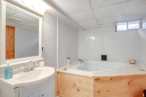 a bathroom with a tub and a sink and a mirror at Coopersburg Vacation Rental with Outdoor Oasis! in Coopersburg