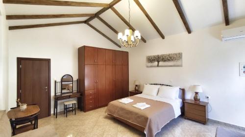 a bedroom with a bed and a table and a chair at Oasis Apartment Ammoudia in Ammoudia