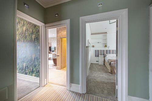 1 dormitorio con puerta que da a una habitación con cama en Escape Boutique B&B, en Llandudno