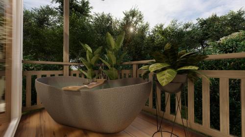 Monteverde Lodge & Gardens by Böëna في مونتيفيردي كوستاريكا: حوض استحمام الجلوس على شرفة مع النباتات