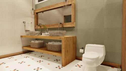 a bathroom with a toilet and a mirror at Monteverde Lodge & Gardens by Böëna in Monteverde Costa Rica