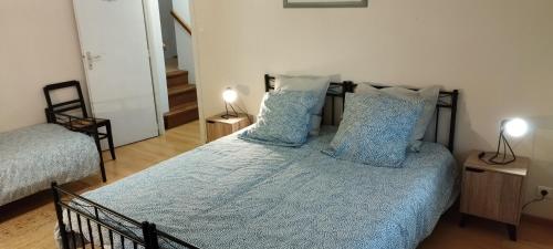 sypialnia z łóżkiem z niebieską pościelą i poduszkami w obiekcie Michel et Florence w mieście Peyrehorade
