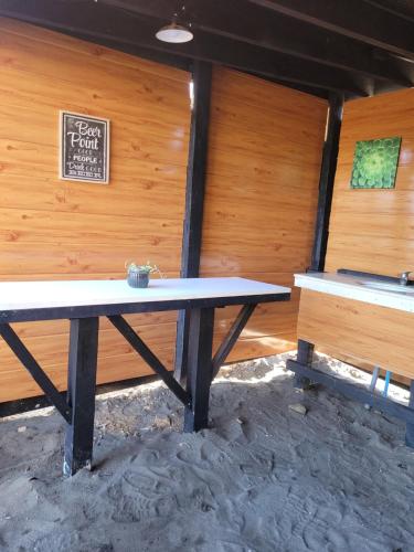 a picnic table in a cabin with a sign on the wall at Casa con vista al mar in Pelluhue