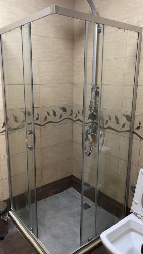 a shower with a glass door next to a sink at Abu Arena Hall in Baku