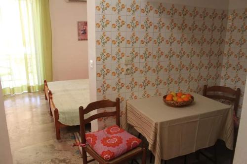 a room with a table and chairs with a bowl of fruit at Cozy double apartment near the sea in Tolo