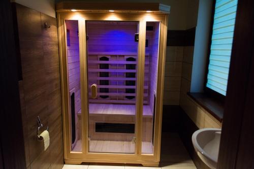 a bathroom with a walk in shower with purple lighting at Jarefka Niezapomniane Chwile in Ciemno
