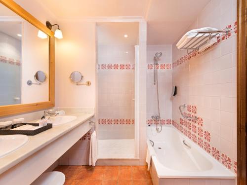 y baño con bañera, lavamanos y ducha. en Hotel Fuerte Conil-Resort, en Conil de la Frontera
