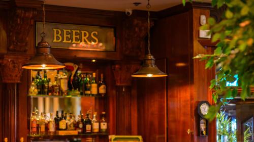 a bar with a shelf with bottles of beer at Flagstaff Lodge in Newry