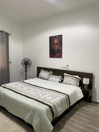 um quarto com uma cama grande e uma fotografia na parede em Luxe akpakpa em Agbato