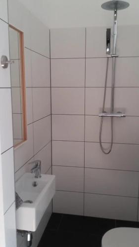 y baño blanco con lavabo y ducha. en Monteurshaus Kalenberg ein Bett Zimmer, en Mechernich