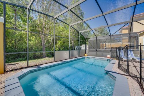 a swimming pool in a house with a glass ceiling at 8 Mi to Disney Villa with Screened Pool and Lanai in Kissimmee