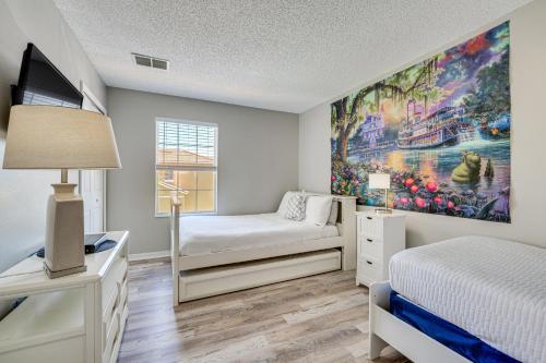 a bedroom with a bed and a desk with a tv at 8 Mi to Disney Villa with Screened Pool and Lanai in Kissimmee