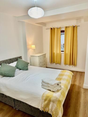 a bedroom with a bed with green and yellow curtains at Saint Saviour's Apt Waterford in Waterford