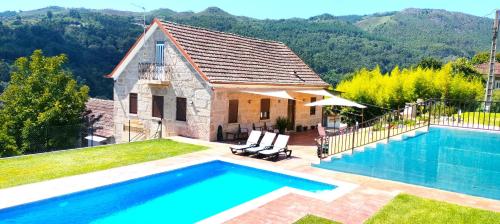 a villa with a swimming pool and a house at Casa A mi Vera in Covelo