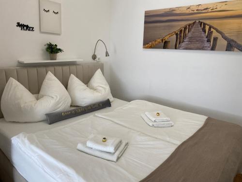 a white bed with two towels on top of it at Rosebeach Appartement am Ossiachersee in Bodensdorf