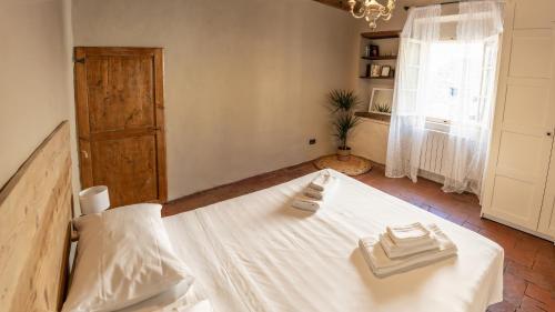 a bedroom with a white bed with towels on it at La Nicchia in San Gimignano