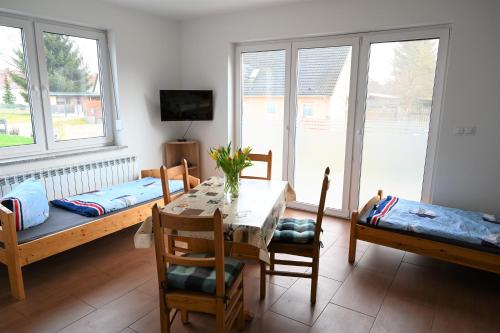 a dining room with a table and chairs and windows at Moderne Unterkunft für Monteure nahe Berlin in Mittenwalde