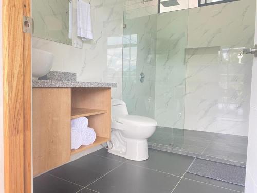 een badkamer met een toilet en een glazen douche bij Villa Tanager in Fortuna
