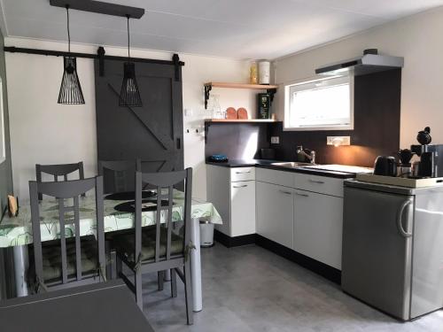 een kleine keuken met een tafel en stoelen. bij De Tip 31 Tiny Chalet in Zeeland