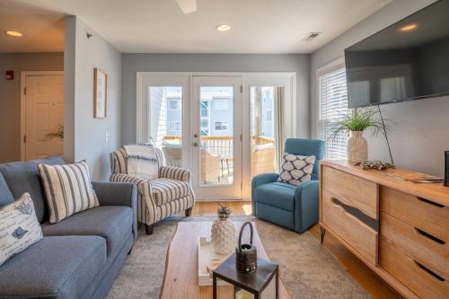 a living room with a blue couch and chairs at Oceanview Condo Near the Boardwalk - Sea Drift Hawks Nest in Carolina Beach