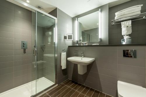 a bathroom with a glass shower and a sink at Mercure London Paddington Hotel in London