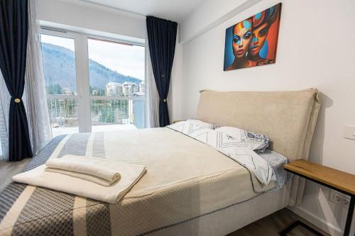 a bedroom with a bed and a large window at Royal Family Apartment in Sinaia