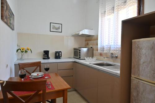 una pequeña cocina con mesa y una pequeña cocina con fregadero en Villa Efterpi, en Kontokali