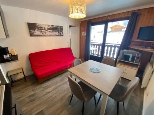 un salon avec un canapé rouge et une table dans l'établissement Bel appartement à Châtel, proche centre et remontées mécaniques, avec balcon et parking - FR-1-693-3, à Châtel