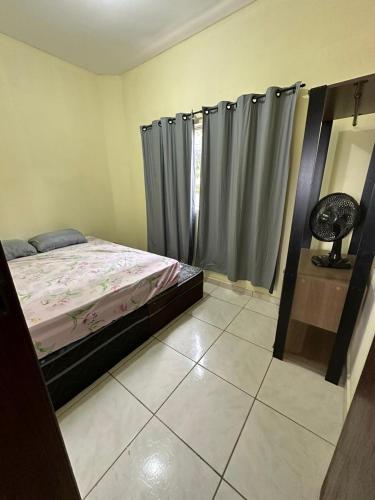 1 dormitorio con cama y cortinas en Apart 2 quartos Ribeiro, en Belo Horizonte