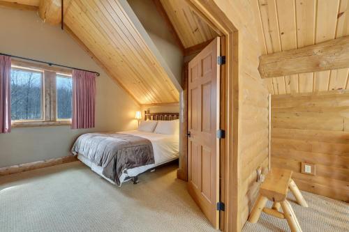 1 dormitorio con cama y techo de madera en 816 Mountain Cabin, en Boyne Falls