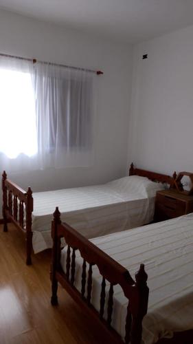two twin beds in a bedroom with a window at Costa Edison in Mar del Plata