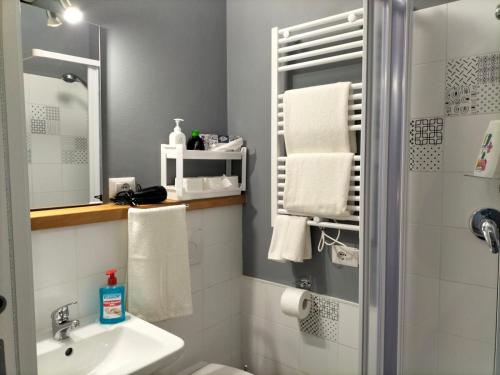 a bathroom with a sink and a shower with towels at Carru de ammentos in Ozieri