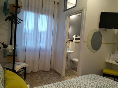 a bedroom with a bed and a toilet and a mirror at Carru de ammentos in Ozieri