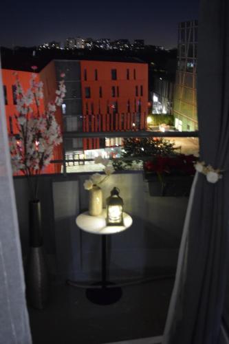 a small table with a lamp on a balcony at night at Remarkable air-con 2-Bed Apartment by Paris in Le Kremlin-Bicêtre