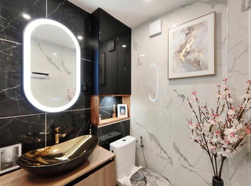La salle de bains est pourvue d'un lavabo, d'un miroir et de toilettes. dans l'établissement Remarkable air-con 2-Bed Apartment by Paris, au Kremlin-Bicêtre
