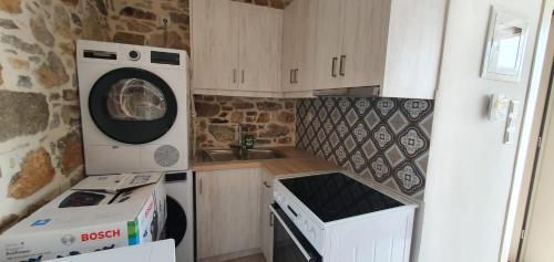 a small kitchen with a washing machine and a sink at SKINOS rooms and apartment in Pyrgi