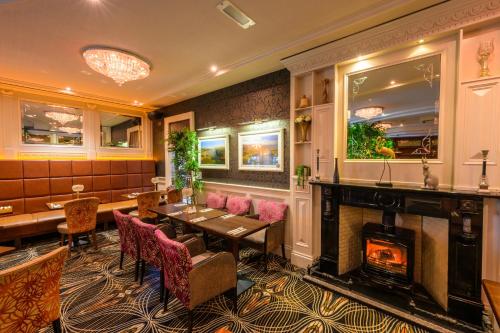 a restaurant with a fireplace and a table and chairs at Flagstaff Lodge in Newry