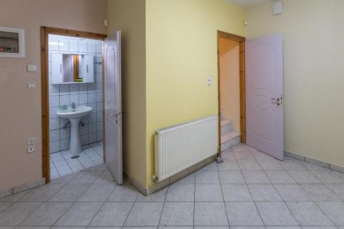 a bathroom with two doors and a sink and a toilet at RENT HOUSE BEACH MIRTOFITO 8 km FROM PERAMOS in Elaiokhórion