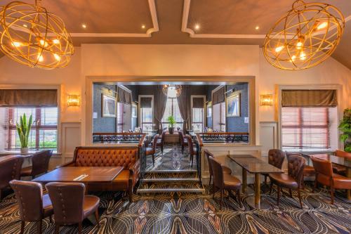 a restaurant with tables and chairs and lights at Flagstaff Lodge in Newry