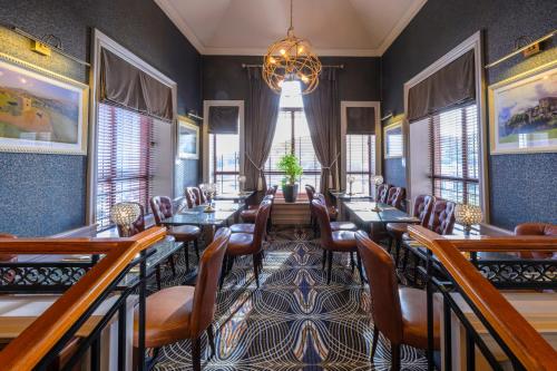 a dining room with tables and chairs and a chandelier at Flagstaff Lodge in Newry