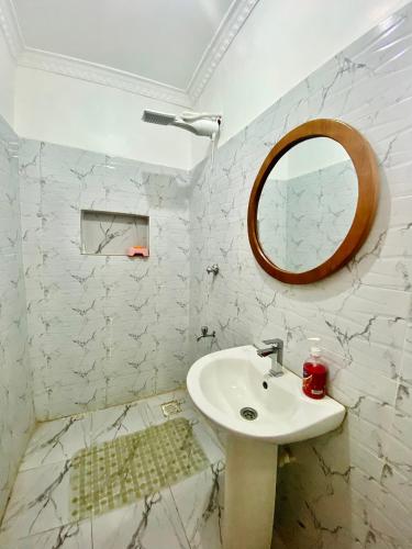 a white bathroom with a sink and a mirror at Kiamboni in Nakuru