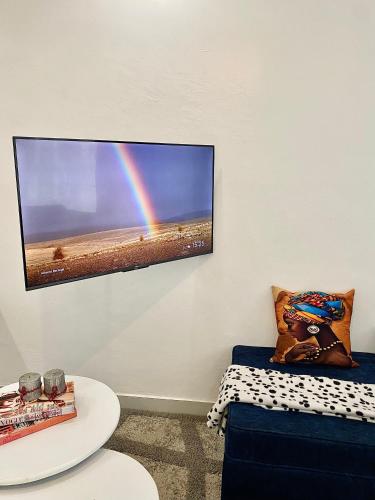 a room with a tv with a rainbow on the wall at Kiamboni in Nakuru