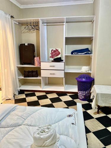 a bedroom with a bed and a checkerboard floor at Kiamboni in Nakuru