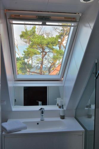 a bathroom with a sink with a window above it at Willa Victor in Jastrzębia Góra