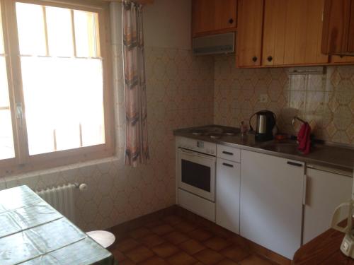 una cucina con lavandino, piano cottura e finestra di Apartment Panorama ad Arolla