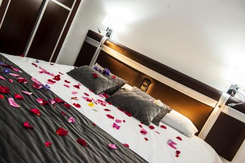 a bed with some rose petals on it at HOSTAL LAS PALOMAS in Lucena