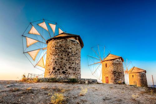 three windmills sitting on top of a hill at Patmos house Leo & Mary in Patmos