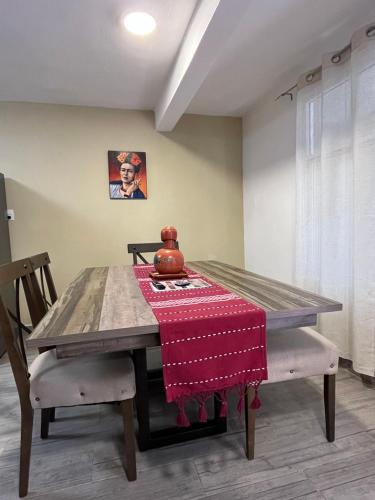 a dining room table with a red blanket on it at Teoti Querido in San Sebastian Xolalpa