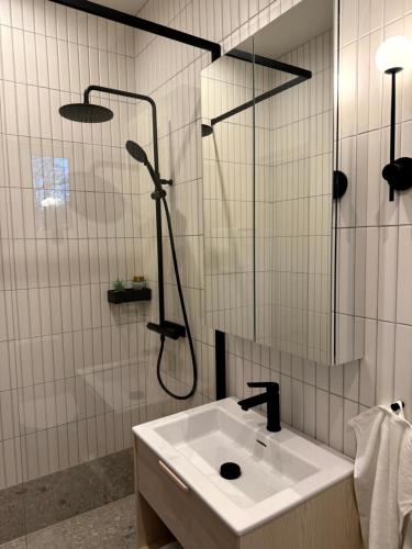 ein Bad mit einer Dusche und einem Waschbecken in der Unterkunft The Embassy in Lund